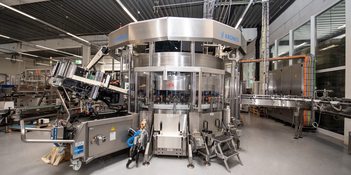 Patented solution for affixing the foil: a servomotor turns the bottles, while linear motors press the foil onto the containers with the aid of sponges. (Picture: Krones)